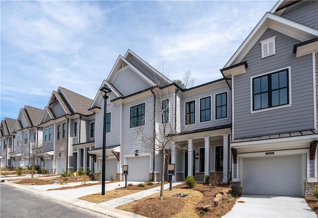 4933 Sudbrook Way Unit 230, Peachtree Corners, GA 30092 - view of property featuring a residential view, a garage, driveway, covered porch, and brick siding