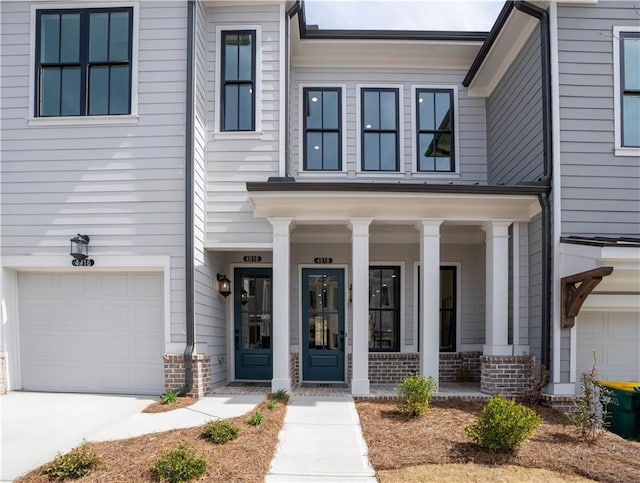 4933 Sudbrook Way Unit 230, Peachtree Corners, GA 30092 - view of front of property with covered porch, a garage, brick siding, and driveway