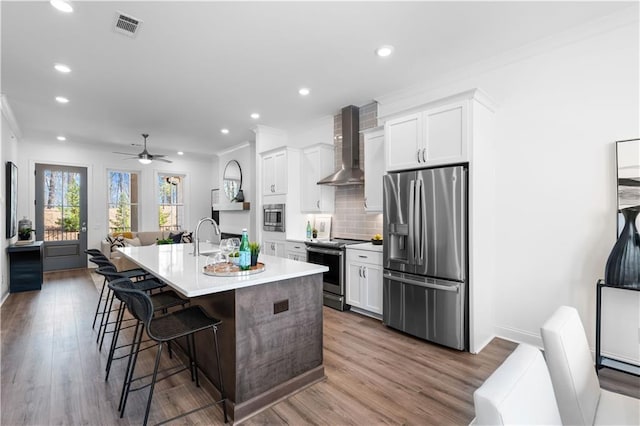 4933 Sudbrook Way Unit 230, Peachtree Corners, GA 30092 - kitchen with appliances with stainless steel finishes, wall chimney range hood, ornamental molding, white cabinetry, and a center island with sink