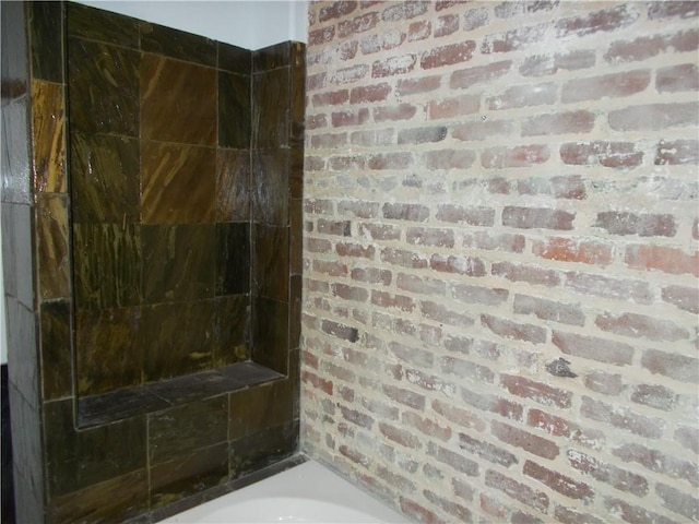 bathroom featuring brick wall