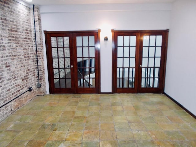 entryway with brick wall and french doors