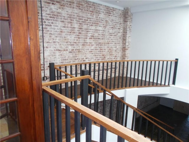 stairway featuring brick wall