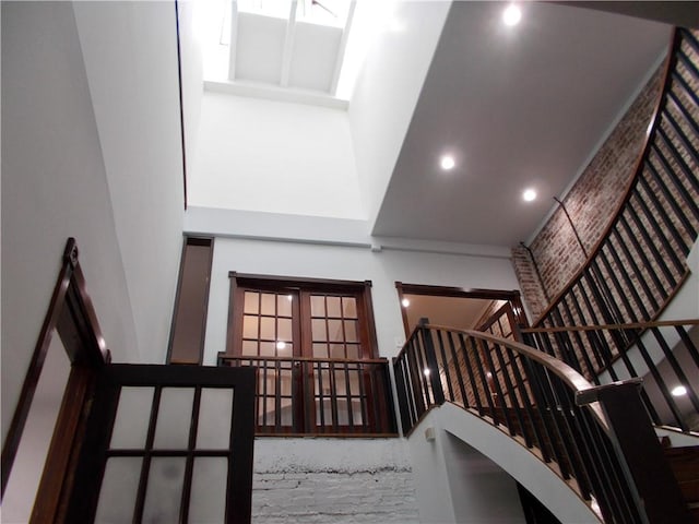 stairway featuring french doors and a high ceiling