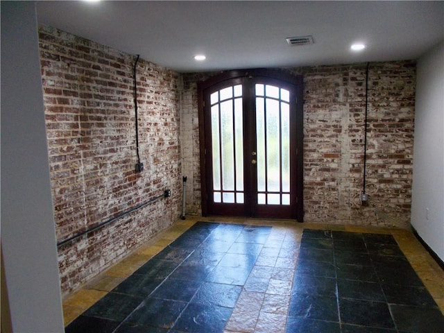 unfurnished room featuring brick wall