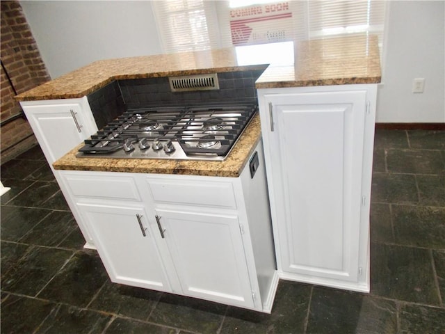 kitchen featuring white cabinets, stone counters, and stainless steel gas cooktop