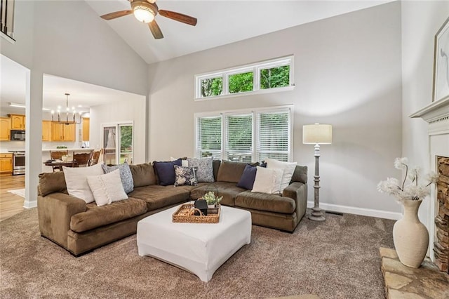 1006 Amberton Ln, Powder Springs, GA 30127 - living area with high vaulted ceiling, a chandelier, a fireplace, a ceiling fan, and light colored carpet