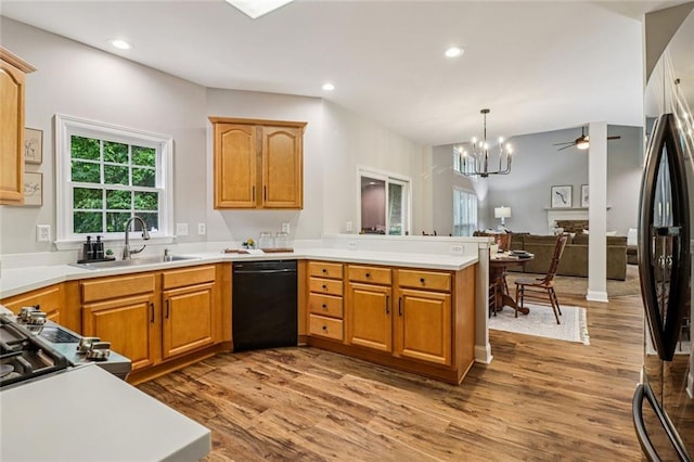 1006 Amberton Ln, Powder Springs, GA 30127 - kitchen with dishwasher, a peninsula, a sink, wood finished floors, and a chandelier