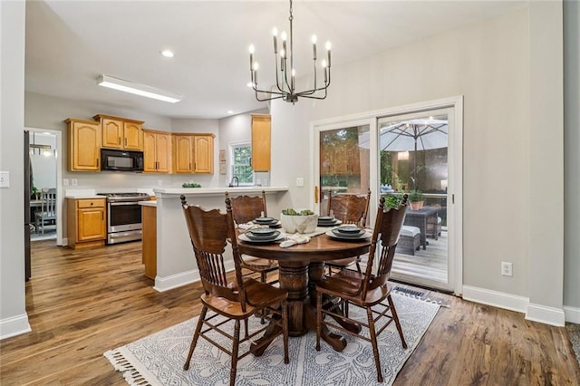 1006 Amberton Ln, Powder Springs, GA 30127 - dining room featuring baseboards, wood finished floors, a chandelier, and recessed lighting