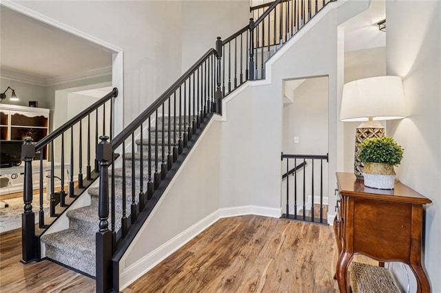 1006 Amberton Ln, Powder Springs, GA 30127 - stairway featuring wood finished floors, baseboards, crown molding, and a high ceiling