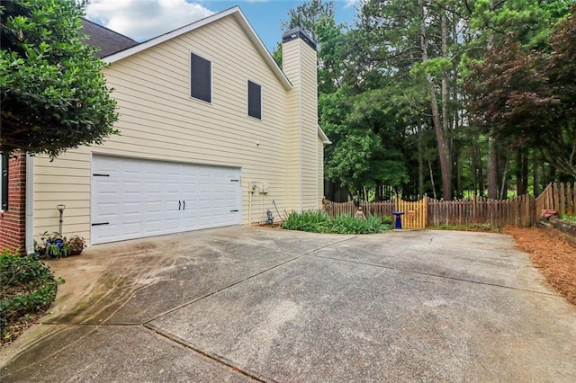 1006 Amberton Ln, Powder Springs, GA 30127 - view of side of property with concrete driveway, a chimney, and an attached garage