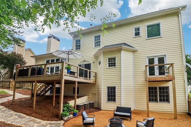 1006 Amberton Ln, Powder Springs, GA 30127 - back of property with an outdoor fire pit, a wooden deck, a patio area, stairway, and a jacuzzi