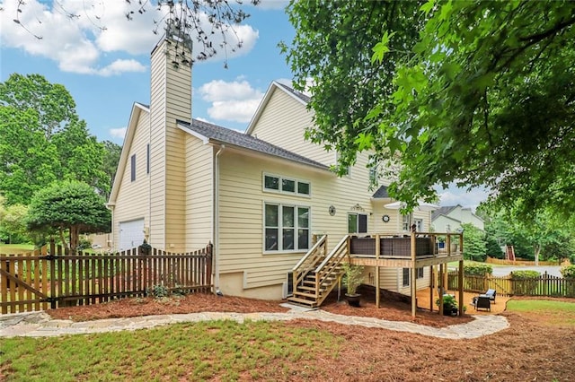 1006 Amberton Ln, Powder Springs, GA 30127 - back of property with stairway, a deck, a chimney, and an attached garage