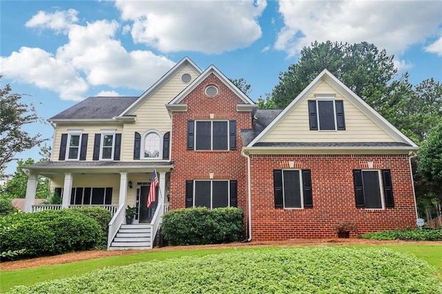 1006 Amberton Ln, Powder Springs, GA 30127 - view of front of house with brick siding, a porch, a front yard, and a shingled roof