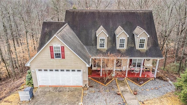 new england style home with a garage and covered porch