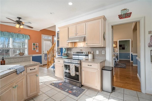 kitchen featuring light tile patterned flooring, light brown cabinetry, tasteful backsplash, double oven range, and ceiling fan