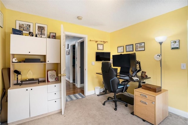 carpeted office space with a textured ceiling