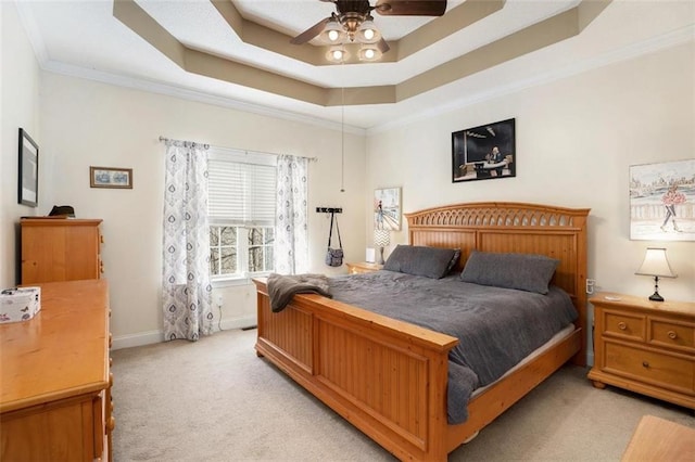 bedroom featuring light carpet, a tray ceiling, ornamental molding, and ceiling fan