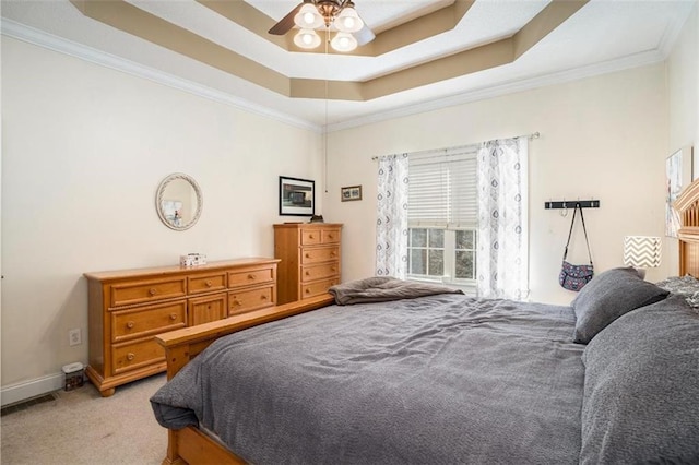 carpeted bedroom featuring ornamental molding, ceiling fan, and a tray ceiling
