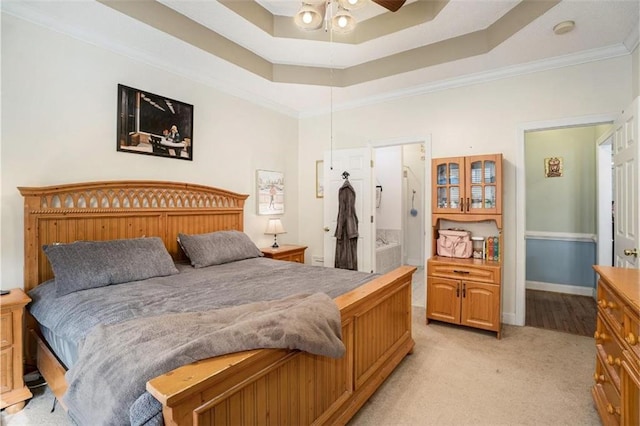 carpeted bedroom featuring a tray ceiling, ornamental molding, and ceiling fan