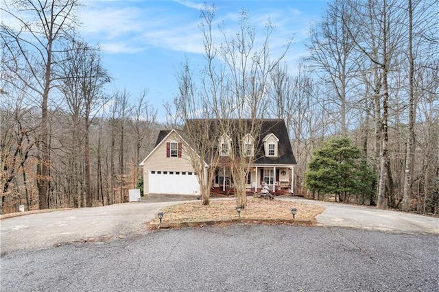 cape cod home with a garage and covered porch