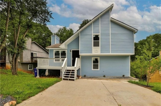 rear view of house with a lawn and a deck