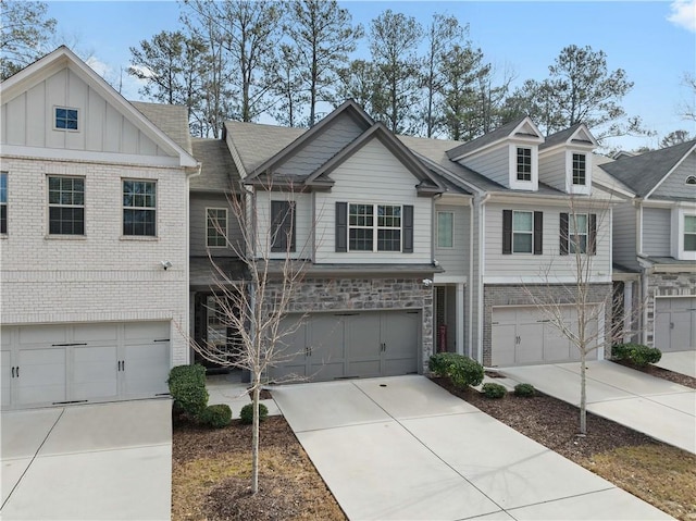 multi unit property featuring a garage, brick siding, board and batten siding, and driveway