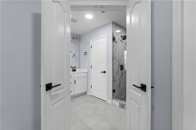 bathroom featuring a marble finish shower, visible vents, and vanity