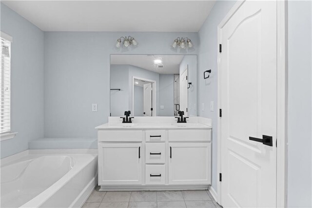 full bathroom with a sink, plenty of natural light, a bath, and double vanity