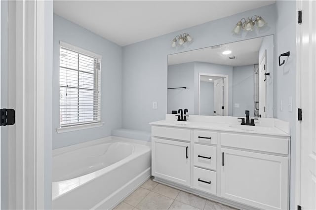 bathroom with double vanity, a bath, a sink, and tile patterned flooring