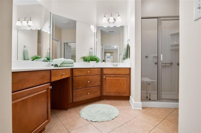 bathroom featuring tile patterned flooring, vanity, and walk in shower