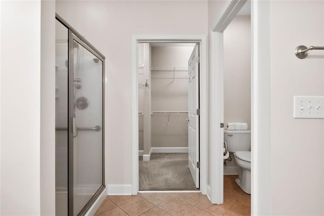 bathroom featuring toilet, tile patterned flooring, and walk in shower