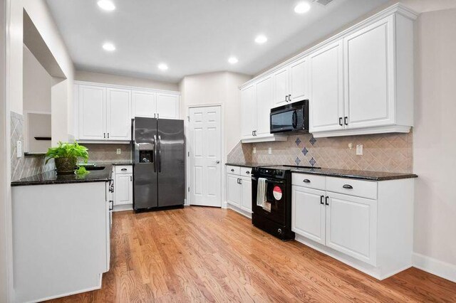 kitchen featuring tasteful backsplash, light hardwood / wood-style flooring, white cabinets, and black appliances