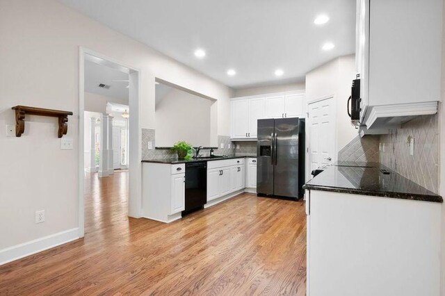 kitchen featuring decorative backsplash, white cabinetry, light hardwood / wood-style flooring, and black appliances