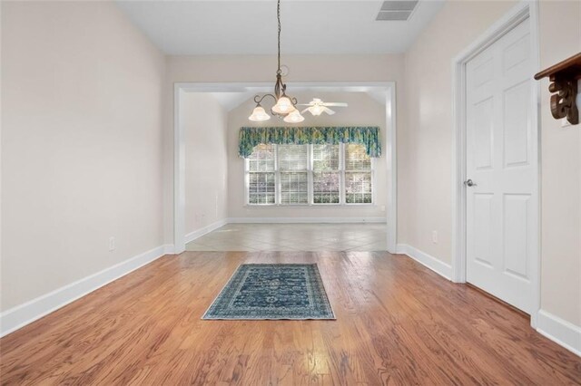 unfurnished dining area featuring hardwood / wood-style flooring and a notable chandelier