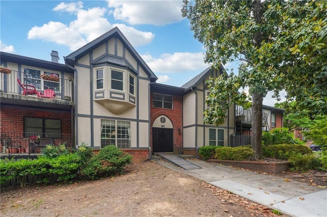 6851 Roswell Rd Unit E1, Atlanta, GA 30328 - tudor home featuring brick siding, stucco siding, and a balcony