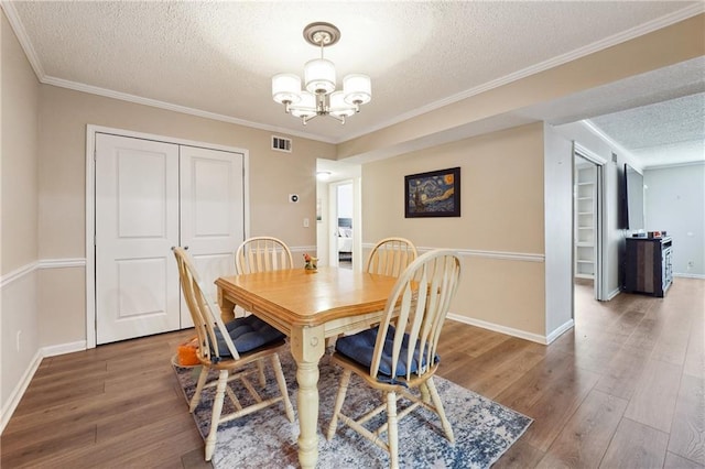 6851 Roswell Rd Unit E1, Atlanta, GA 30328 - dining space with a textured ceiling, visible vents, wood finished floors, and an inviting chandelier