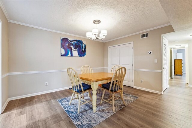 6851 Roswell Rd Unit E1, Atlanta, GA 30328 - dining room featuring a textured ceiling, visible vents, an inviting chandelier, and wood finished floors