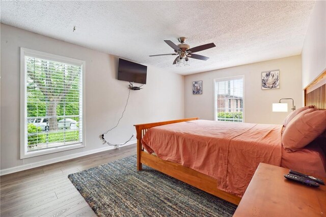 6851 Roswell Rd Unit E1, Atlanta, GA 30328 - bedroom with baseboards, a ceiling fan, a textured ceiling, and wood finished floors