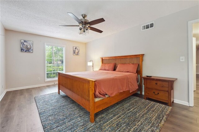6851 Roswell Rd Unit E1, Atlanta, GA 30328 - bedroom featuring a textured ceiling, baseboards, visible vents, and wood finished floors