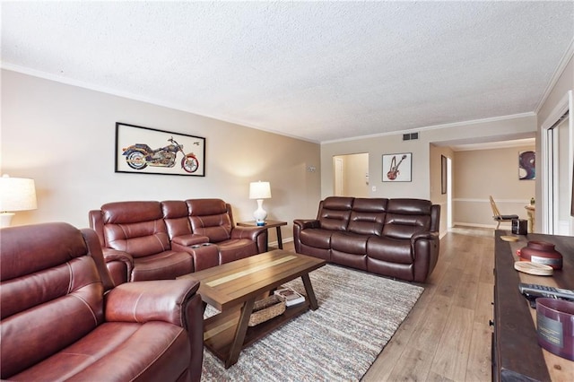 living room featuring ornamental molding, light hardwood / wood-style floors, and a textured ceiling