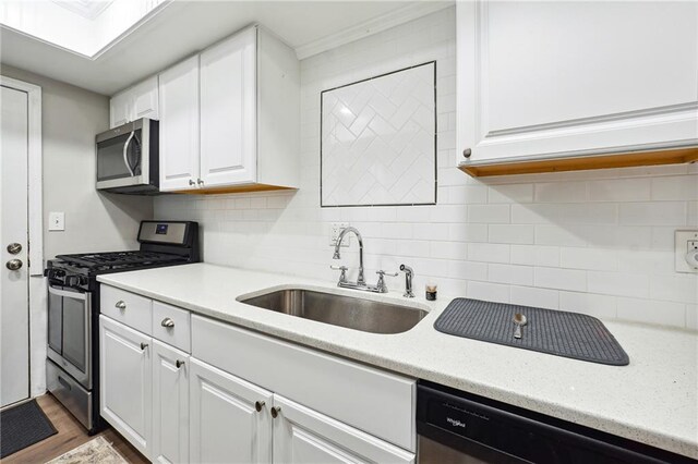 6851 Roswell Rd Unit E1, Atlanta, GA 30328 - kitchen featuring wood finished floors, white cabinets, tasteful backsplash, a sink, and stainless steel appliances