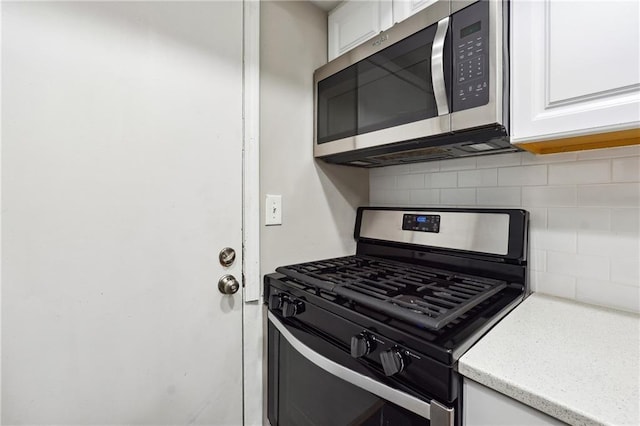6851 Roswell Rd Unit E1, Atlanta, GA 30328 - kitchen with backsplash, white cabinets, and appliances with stainless steel finishes
