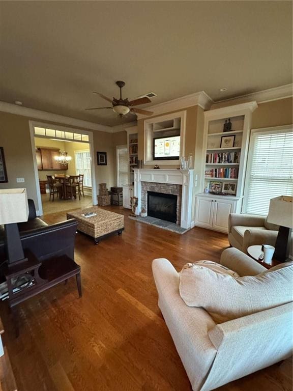 living room with ornamental molding, ceiling fan, a fireplace, and dark hardwood / wood-style flooring