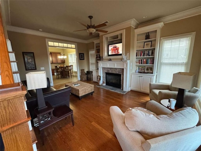 living room featuring dark wood-type flooring, ceiling fan, ornamental molding, and a fireplace