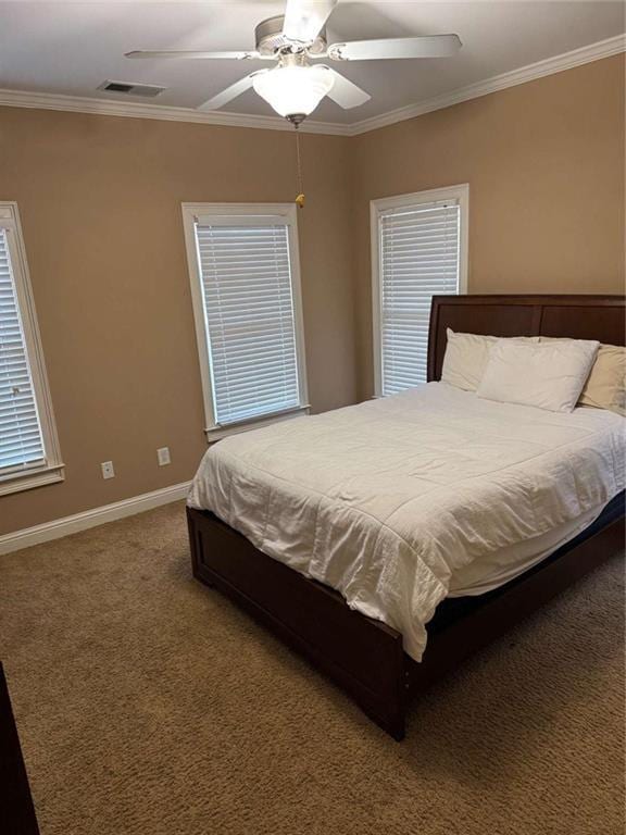 bedroom with crown molding, ceiling fan, and carpet floors