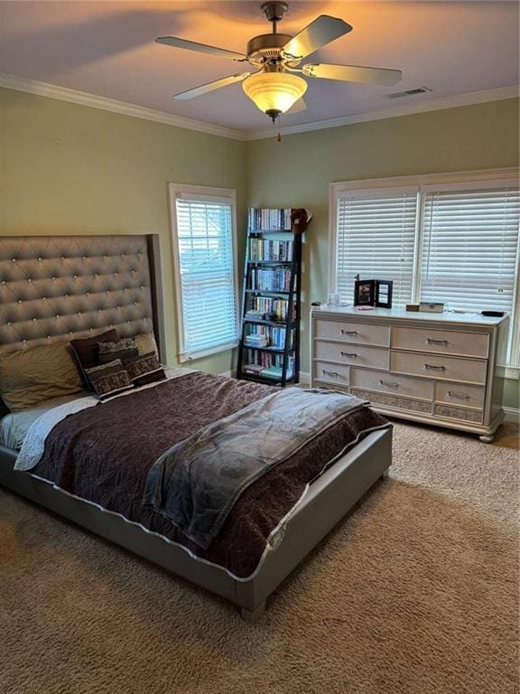 bedroom with ceiling fan, ornamental molding, and carpet flooring