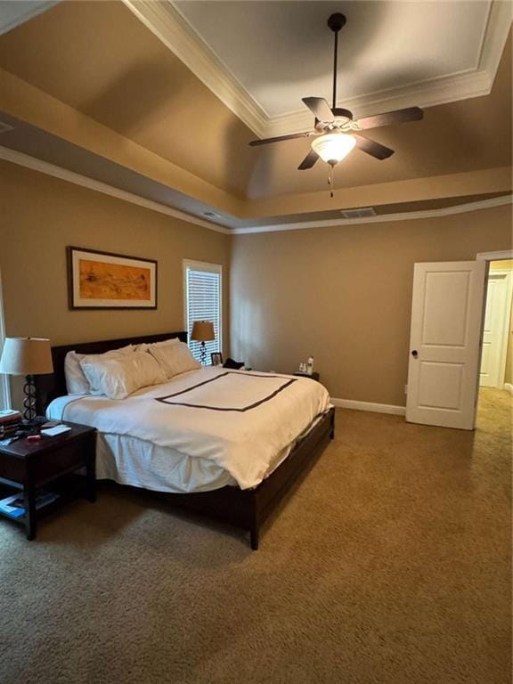 bedroom with ceiling fan, ornamental molding, a tray ceiling, and carpet