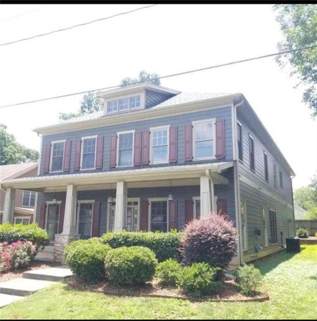 view of front of house with a porch and a front yard