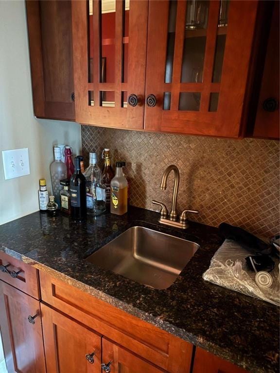 kitchen featuring dark stone countertops, sink, and tasteful backsplash