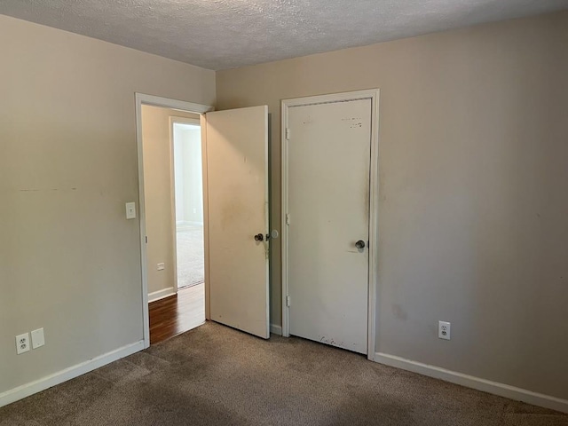 unfurnished bedroom with carpet and a textured ceiling